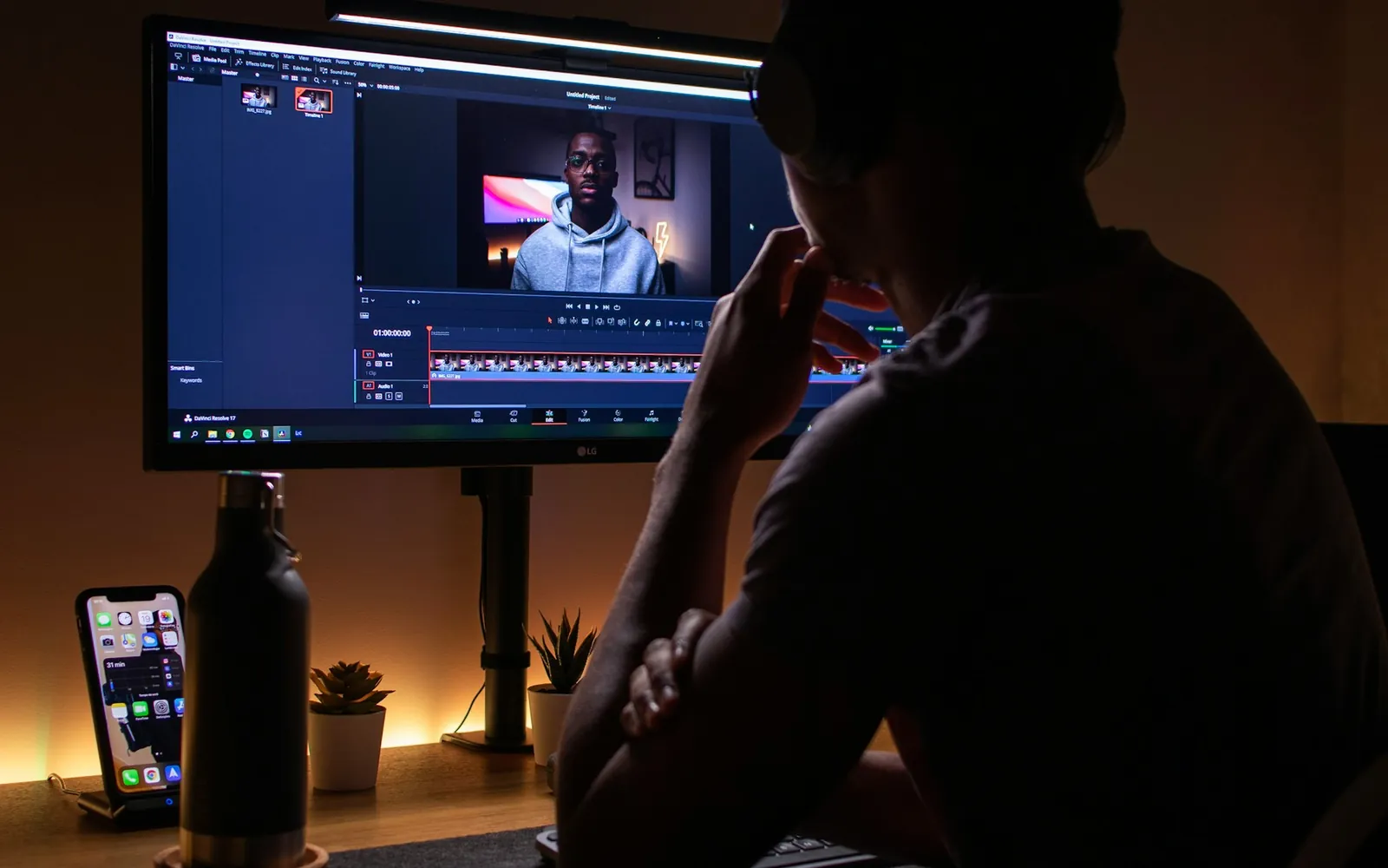 A video editor wearing headphones cutting an interview on a timeline.