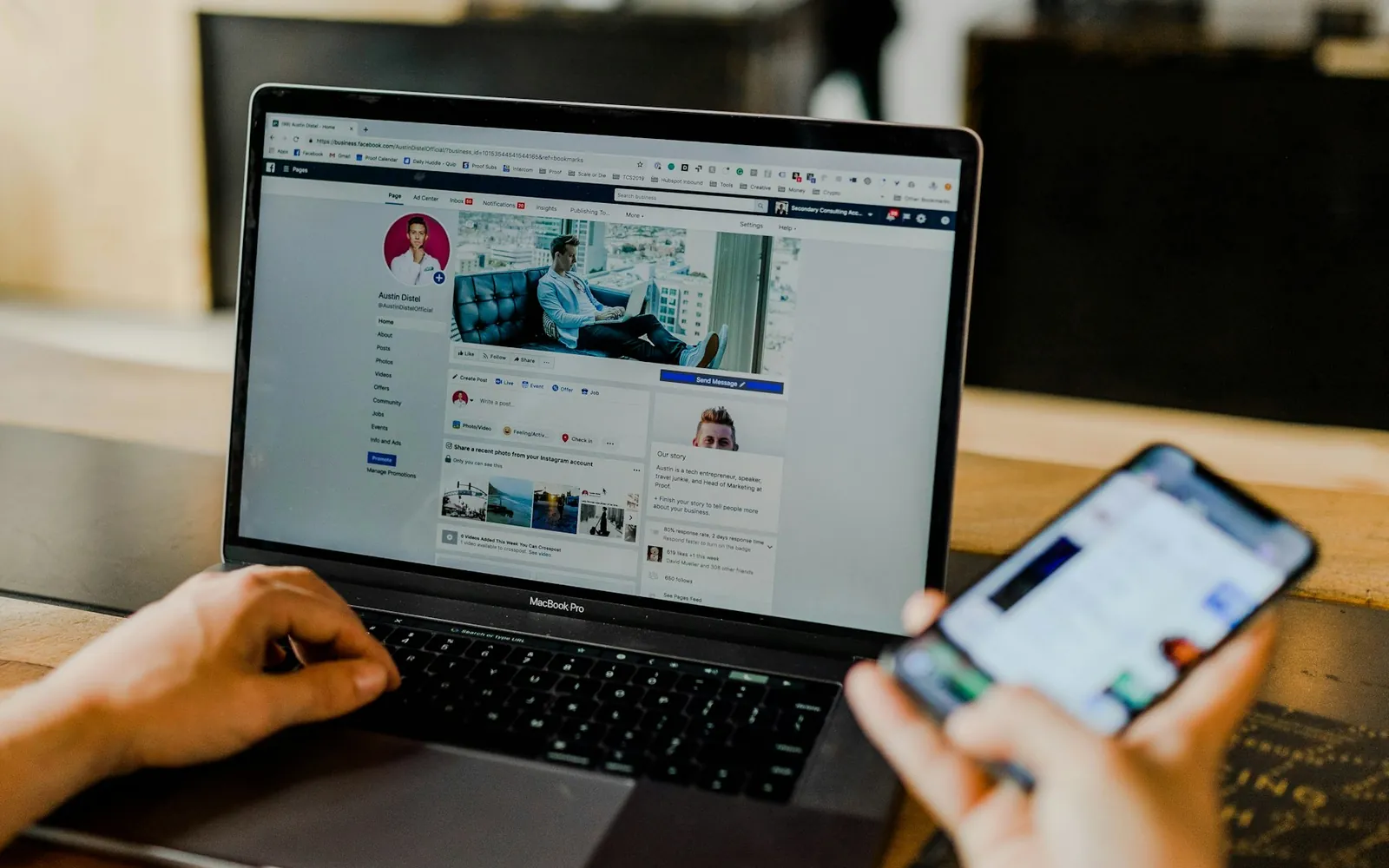 A marketer managing a social media page on a laptop and phone.