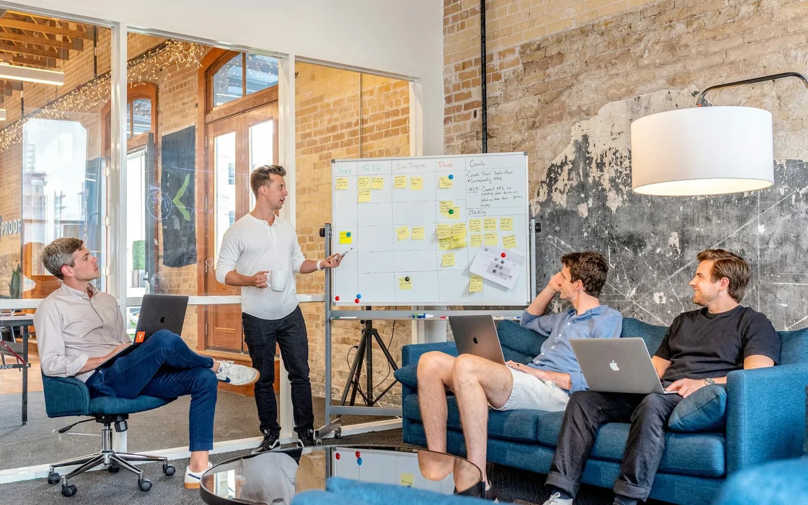 A startup team planning a product at a whiteboard in a shared workspace.